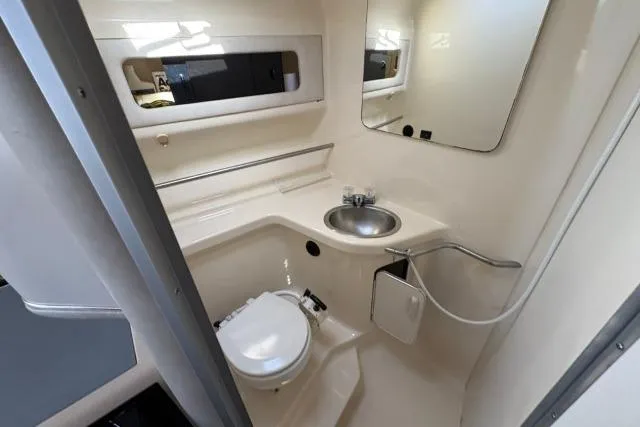 Slide: The Image of 1993 Sea Ray Sundancer 330 bathroom with sink, toilet, and mirror in compact layout. - 86