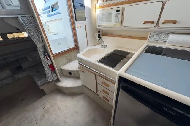 Slide: The Image of Interior of 1993 Sea Ray Sundancer 330 yacht, featuring a compact kitchen area. - 89