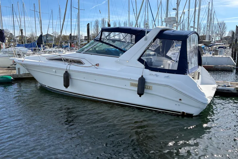 Slide: The Image of 1993 Sea Ray Sundancer 330 yacht docked in a marina, surrounded by sailboats. - 9