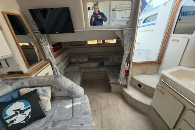 Slide: The Image of Interior of a 1993 Sea Ray Sundancer 330 yacht, featuring cozy seating and modern amenities. - 92