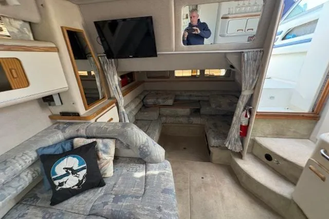 Slide: The Image of Interior of a 1993 Sea Ray Sundancer 330 boat with seating, TV, and nautical decor. - 93