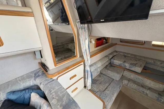 Slide: The Image of Interior of a 1993 Sea Ray Sundancer 330 with cozy seating and a mounted TV. - 95