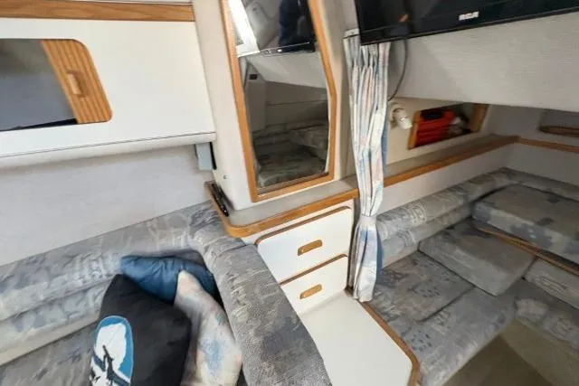 Slide: The Image of Interior of a 1993 Sea Ray Sundancer 330, featuring cozy seating and storage. - 96