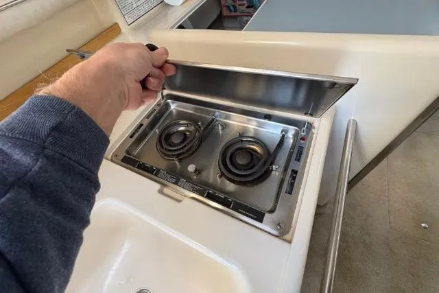 Slide: The Image of Stove on 1993 Sea Ray Sundancer 330 yacht, featuring dual burners and stainless steel cover. - 99