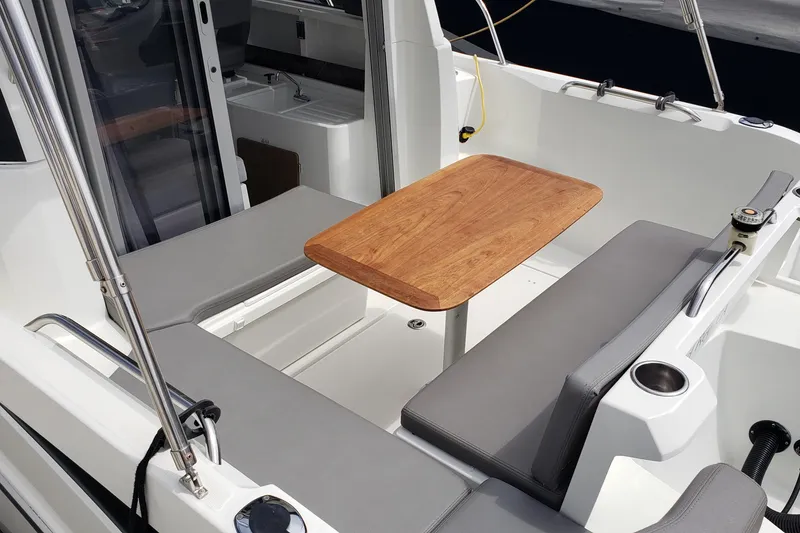 Slide: The Image of 2019 Beneteau Antares 23 boat interior with wooden table and gray seating. - 10