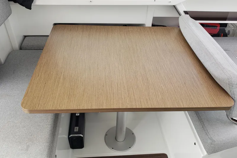 Slide: The Image of Interior view of 2019 Beneteau Antares 23, featuring a wooden table and gray seating. - 19