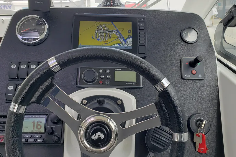 Slide: The Image of Steering console of a 2019 Beneteau Antares 23 with navigation display and controls. - 22