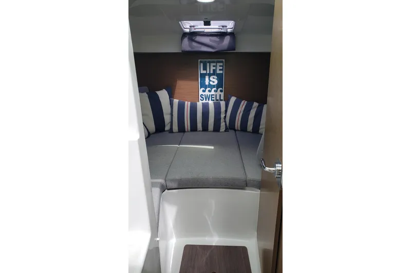 Slide: The Image of Cozy cabin interior of 2019 Beneteau Antares 23 with striped cushions and decor. - 29
