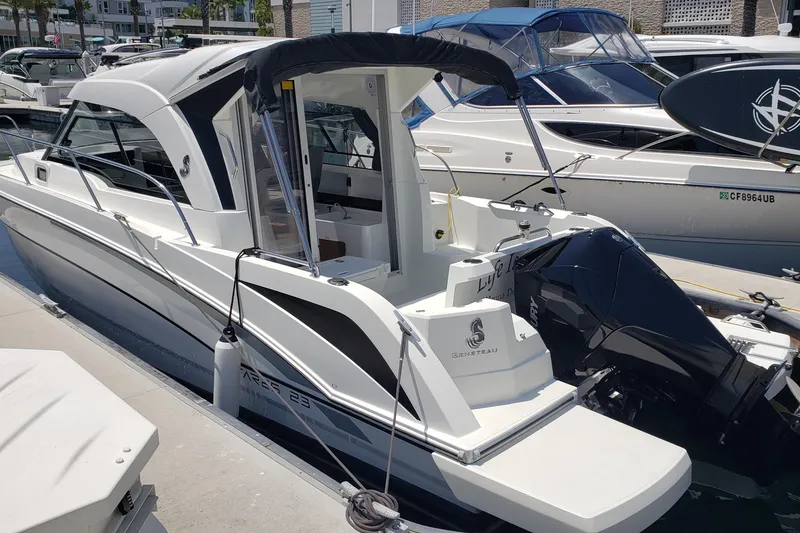 Slide: The Image of 2019 Beneteau Antares 23 boat docked, featuring sleek design and powerful outboard motor. - 45