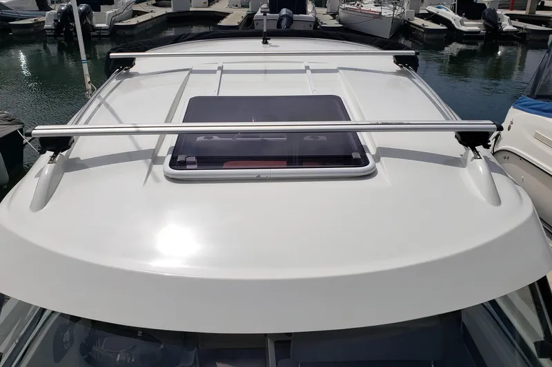 Slide: The Image of 2019 Beneteau Antares 23 boat roof with hatch and railing at marina. - 6