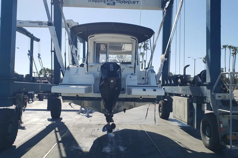 Slide: The Image of 2019 Beneteau Antares 23 boat lifted by Marine Travelift at a dockyard. - 63