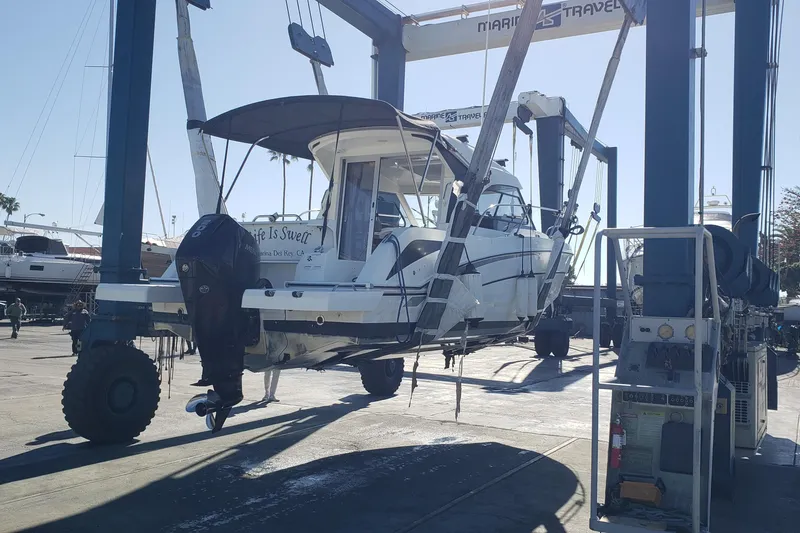Slide: The Image of 2019 Beneteau Antares 23 boat lifted by crane at marina. - 64