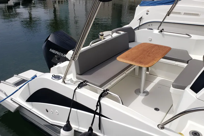 Slide: The Image of 2019 Beneteau Antares 23 boat with seating area and wooden table on deck. - 8