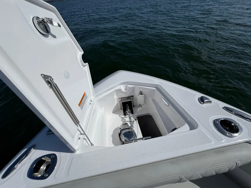 Slide: The Image of 2022 Everglades 235 Center Console boat anchor compartment open on calm water. - 12