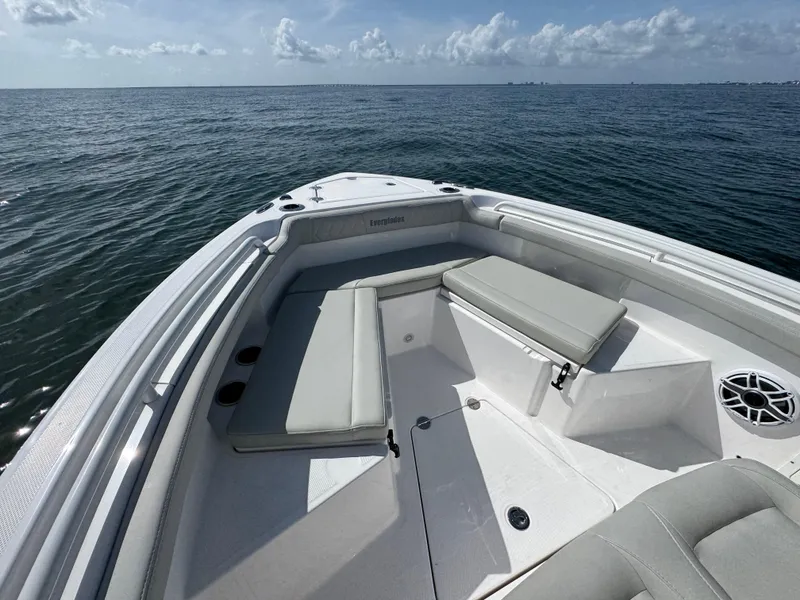Slide: The Image of 2022 Everglades 235 Center Console boat with cushioned seating, on calm ocean waters. - 13
