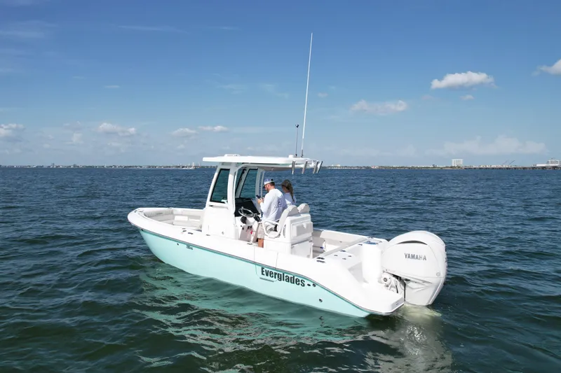 Slide: The Image of 2022 Everglades 235 Center Console boat cruising on open water under clear skies. - 2