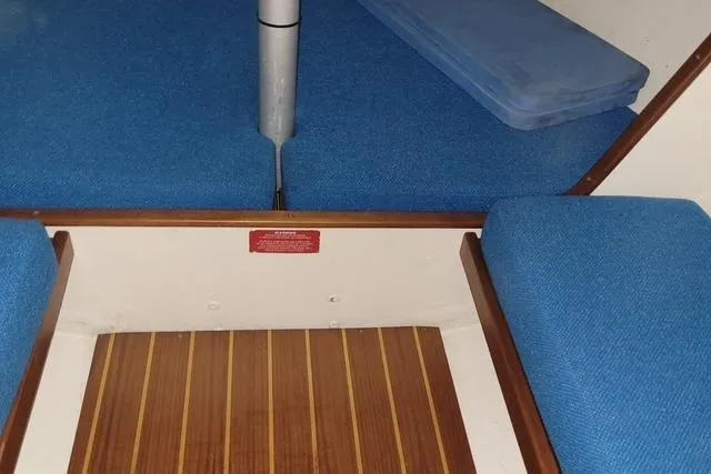 Slide: The Image of Interior of a 1988 J Boats J/22 sailboat with blue cushions and wooden flooring. - 5