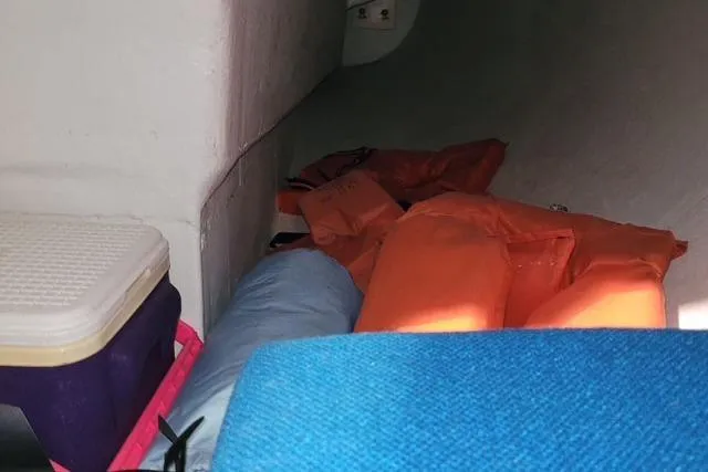 Slide: The Image of Interior of a 1988 J Boats J/22 sailboat with life jackets and storage items. - 8