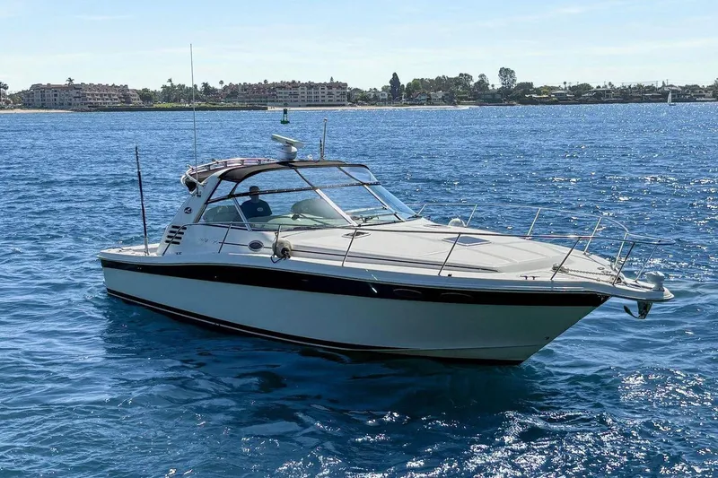 The Image of 1997 Sea Ray 370 Express Cruiser on calm blue water under clear sky. - 0