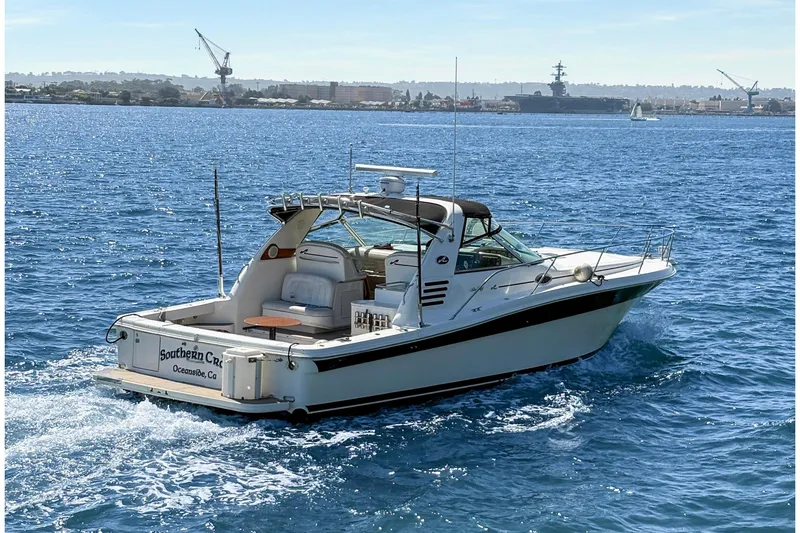 Slide: The Image of 1997 Sea Ray 370 Express Cruiser on open water, sunny day, coastal backdrop. - 10