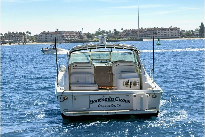 Slide: The Image of 1997 Sea Ray 370 Express Cruiser docked at marina, with cityscape backdrop. - 11