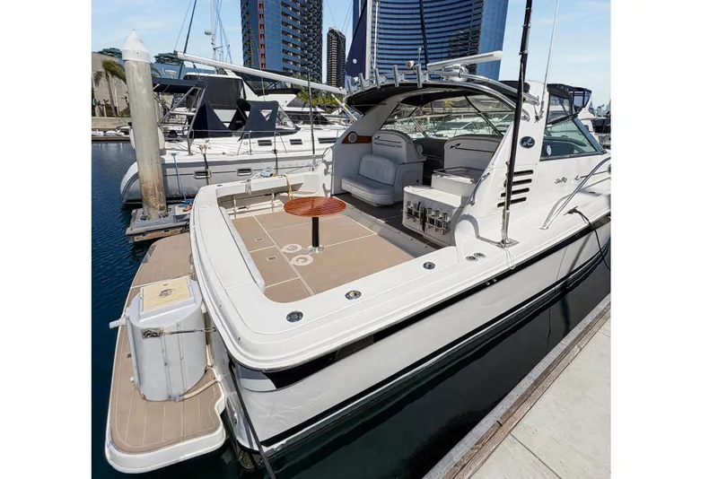 Slide: The Image of 1997 Sea Ray 370 Express Cruiser interior with seating and table, docked at marina. - 15