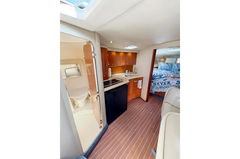 Slide: The Image of 1997 Sea Ray 370 Express Cruiser cabin with cozy bed and nautical decor. - 24