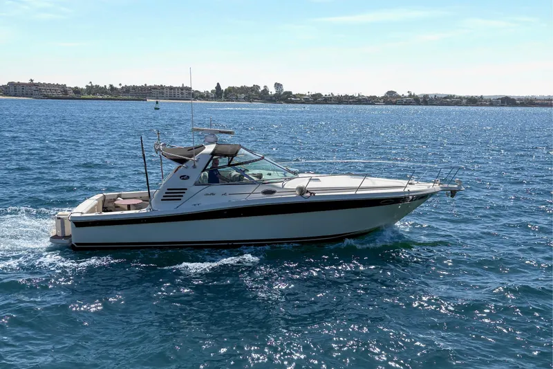 Slide: The Image of 1997 Sea Ray 370 Express Cruiser sailing on open water under clear skies. - 9