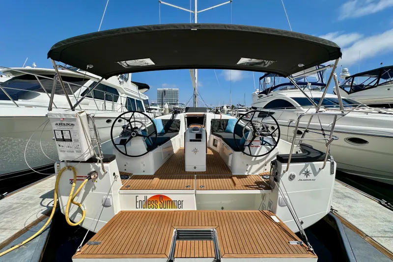 Slide: The Image of 2024 Jeanneau Sun Odyssey 410 sailboat with dual steering wheels, docked at a marina. - 13
