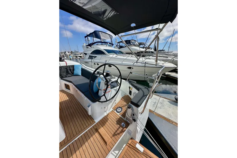 Slide: The Image of 2024 Jeanneau Sun Odyssey 410 sailboat cockpit with steering wheel, docked at marina. - 17
