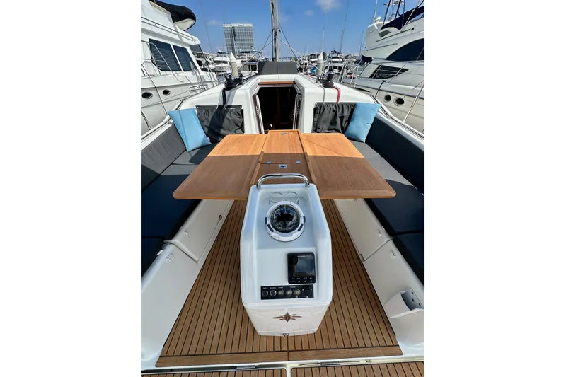 Slide: The Image of 2024 Jeanneau Sun Odyssey 410 yacht cockpit with wooden table and seating. - 24