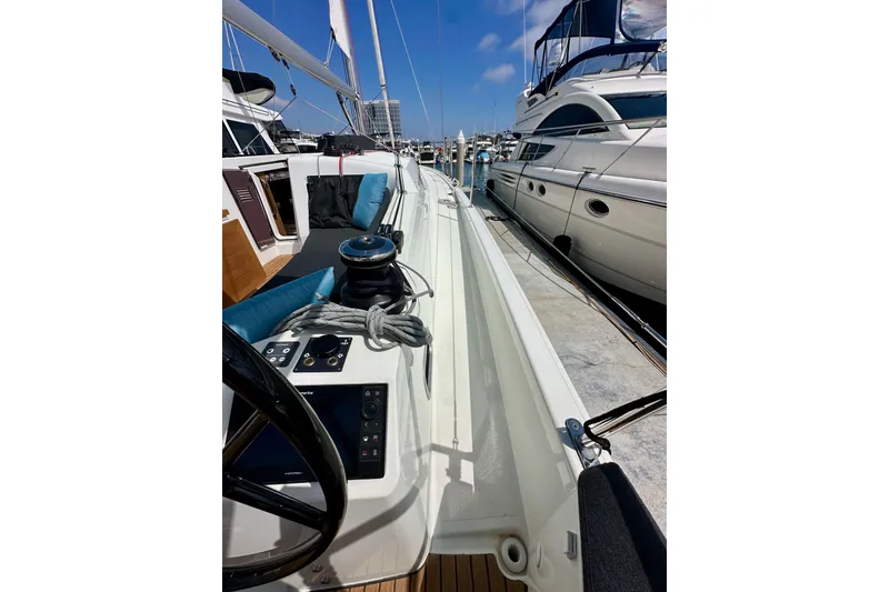 Slide: The Image of 2024 Jeanneau Sun Odyssey 410 sailboat docked, showcasing deck and steering wheel. - 28