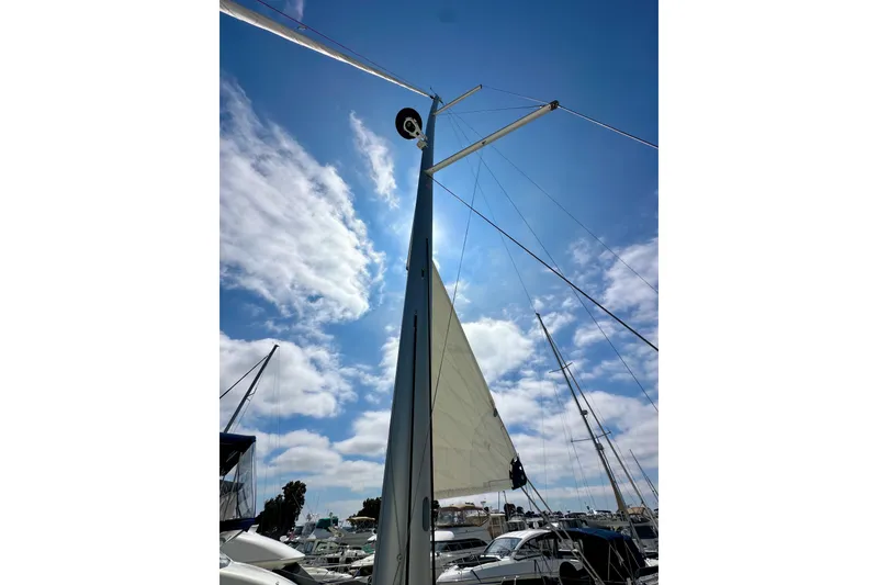 Slide: The Image of Sailboat mast and sail of 2024 Jeanneau Sun Odyssey 410 against a blue sky. - 39