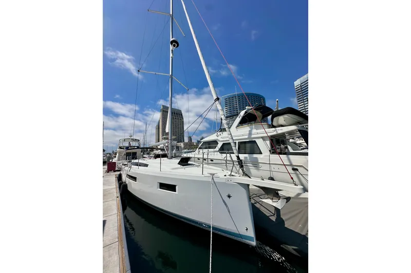 Slide: The Image of 2024 Jeanneau Sun Odyssey 410 sailboat docked in marina, clear blue sky background. - 6