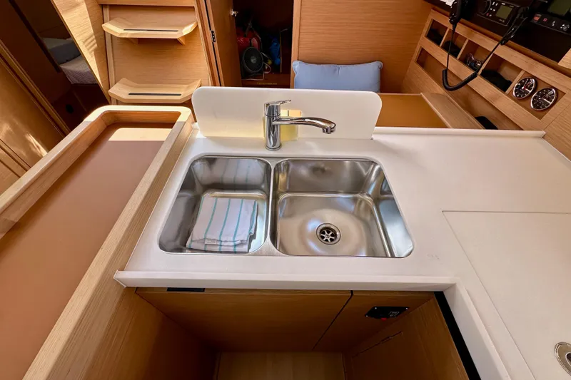 Slide: The Image of 2024 Jeanneau Sun Odyssey 410 yacht kitchen with dual sink and modern wood cabinetry. - 75