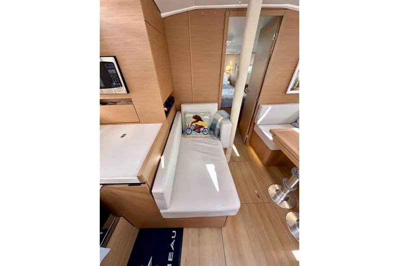 Slide: The Image of Interior of 2024 Jeanneau Sun Odyssey 410 yacht, featuring modern wood finish and cozy seating. - 83