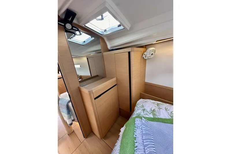 Slide: The Image of 2024 Jeanneau Sun Odyssey 410 interior cabin with wooden cabinetry and skylight. - 87