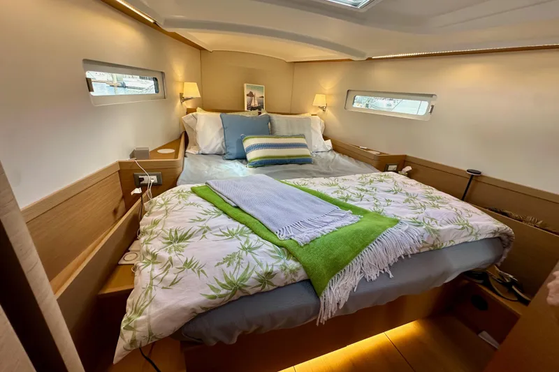 Slide: The Image of Luxurious cabin interior of 2024 Jeanneau Sun Odyssey 410 sailboat, featuring cozy bedding. - 90