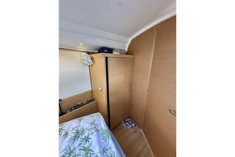 Slide: The Image of 2024 Jeanneau Sun Odyssey 410 cabin interior with wooden cabinetry and bed. - 92