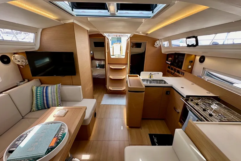 Slide: The Image of Luxurious interior of 2024 Jeanneau Sun Odyssey 410 sailboat, featuring modern kitchen and seating area. - 96
