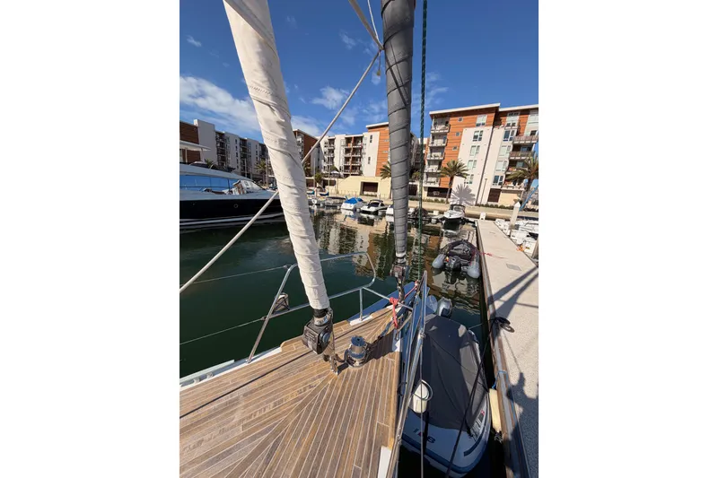 Slide: The Image of Beneteau Oceanis Yacht 60, 2015 model, docked in a marina with modern buildings. - 12