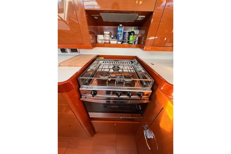 Slide: The Image of Galley kitchen in 2015 Beneteau Oceanis Yacht 60 with stove and wooden cabinetry. - 45