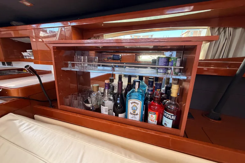 Slide: The Image of Luxurious bar area on 2015 Beneteau Oceanis Yacht 60 with assorted spirits and glassware. - 78