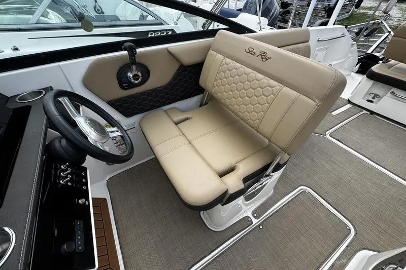 Slide: The Image of Captain's seat of 2019 Sea Ray SDX 250 boat, featuring beige upholstery and steering wheel. - 15