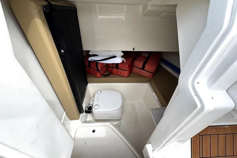 Slide: The Image of 2019 Sea Ray SDX 250 boat interior with compact toilet and life jackets. - 16