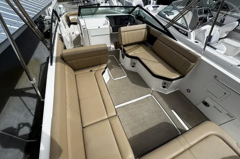 Slide: The Image of 2019 Sea Ray SDX 250 boat interior with tan seating and modern dashboard. - 22
