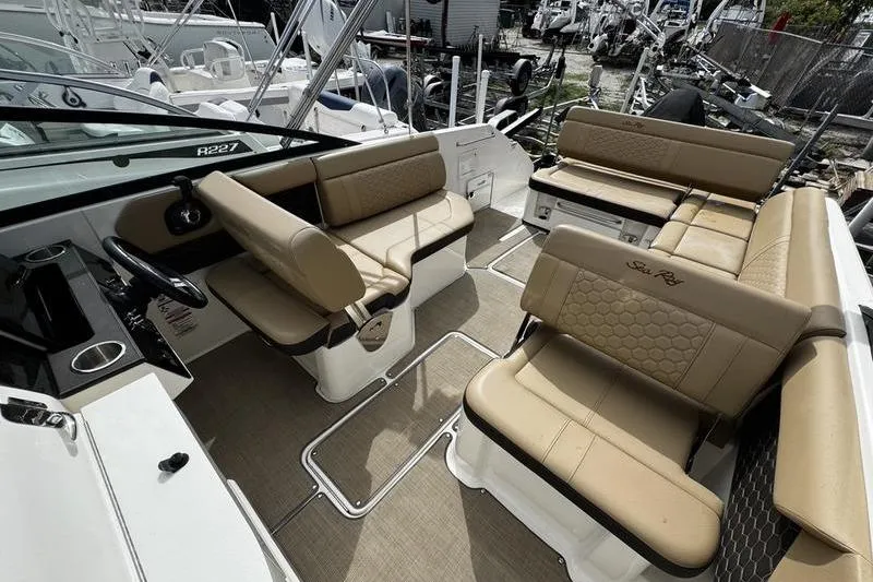 Slide: The Image of 2019 Sea Ray SDX 250 boat interior with tan seating and steering console. - 26