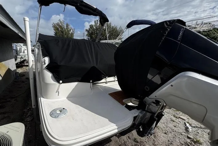 Slide: The Image of 2019 Sea Ray SDX 250 boat with black cover and outboard motor, docked outdoors. - 6