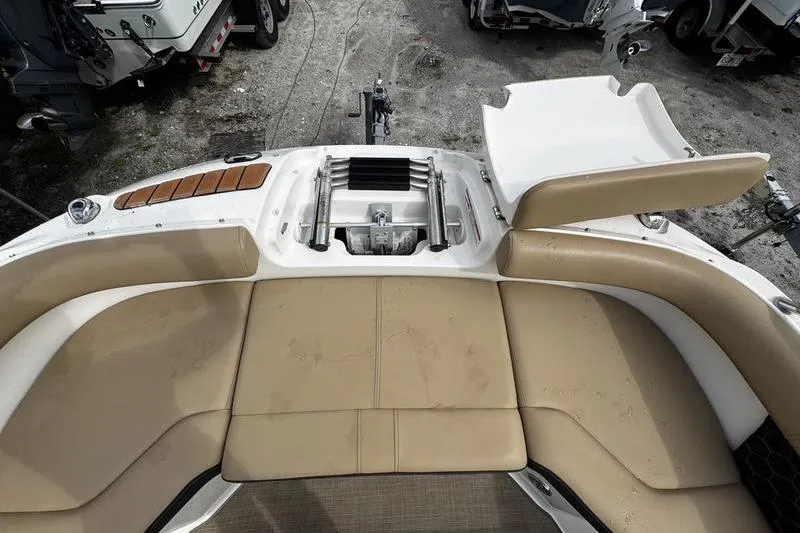 Slide: The Image of 2019 Sea Ray SDX 250 boat interior with beige seating and storage compartment. - 9