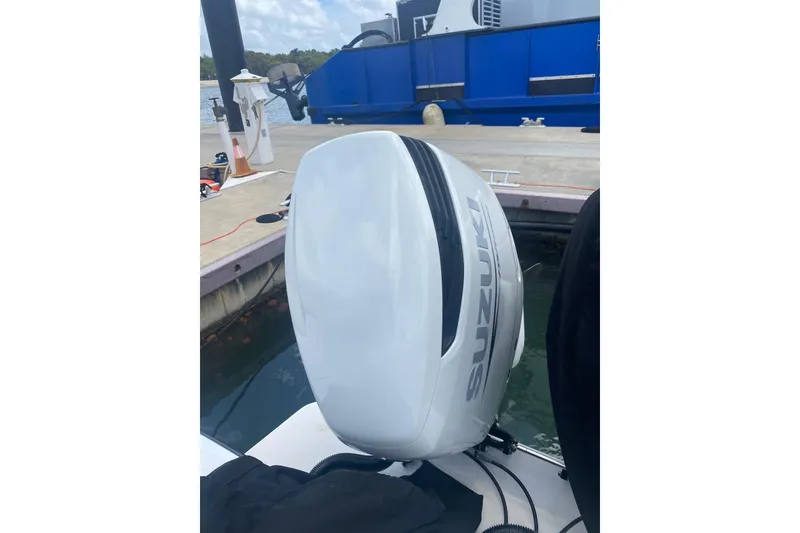 Slide: The Image of White Suzuki outboard motor on a docked boat, Salt Shaker 300 model, 1990. - 10